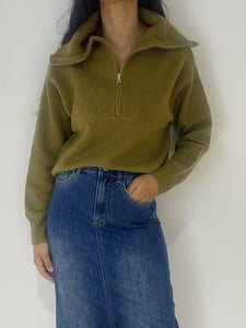 Femme portant un pull vert à col montant avec fermeture éclair