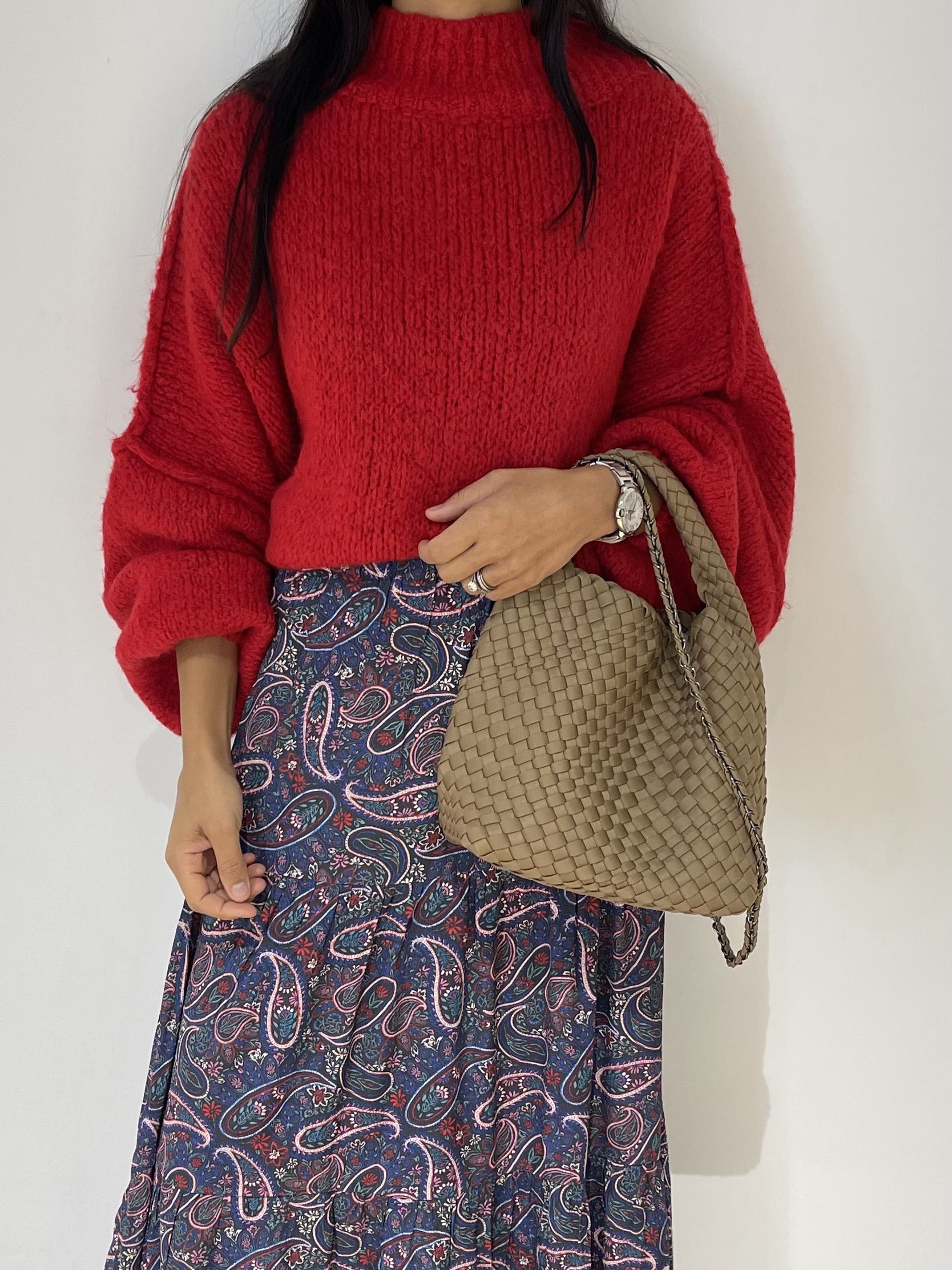 Femme tendance avec pull oversize rouge en laine et jupe imprimée