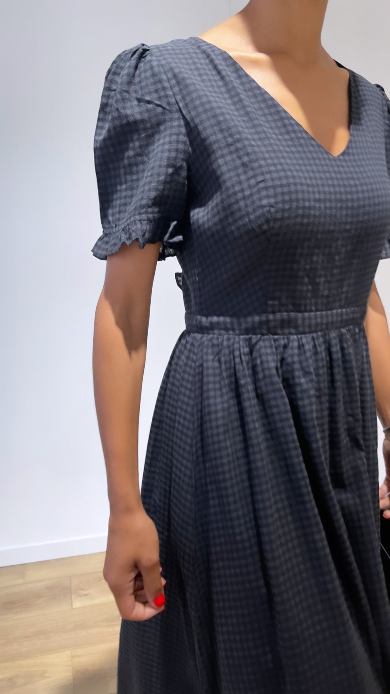 Détail de la robe en coton noir à col en V pour femme
