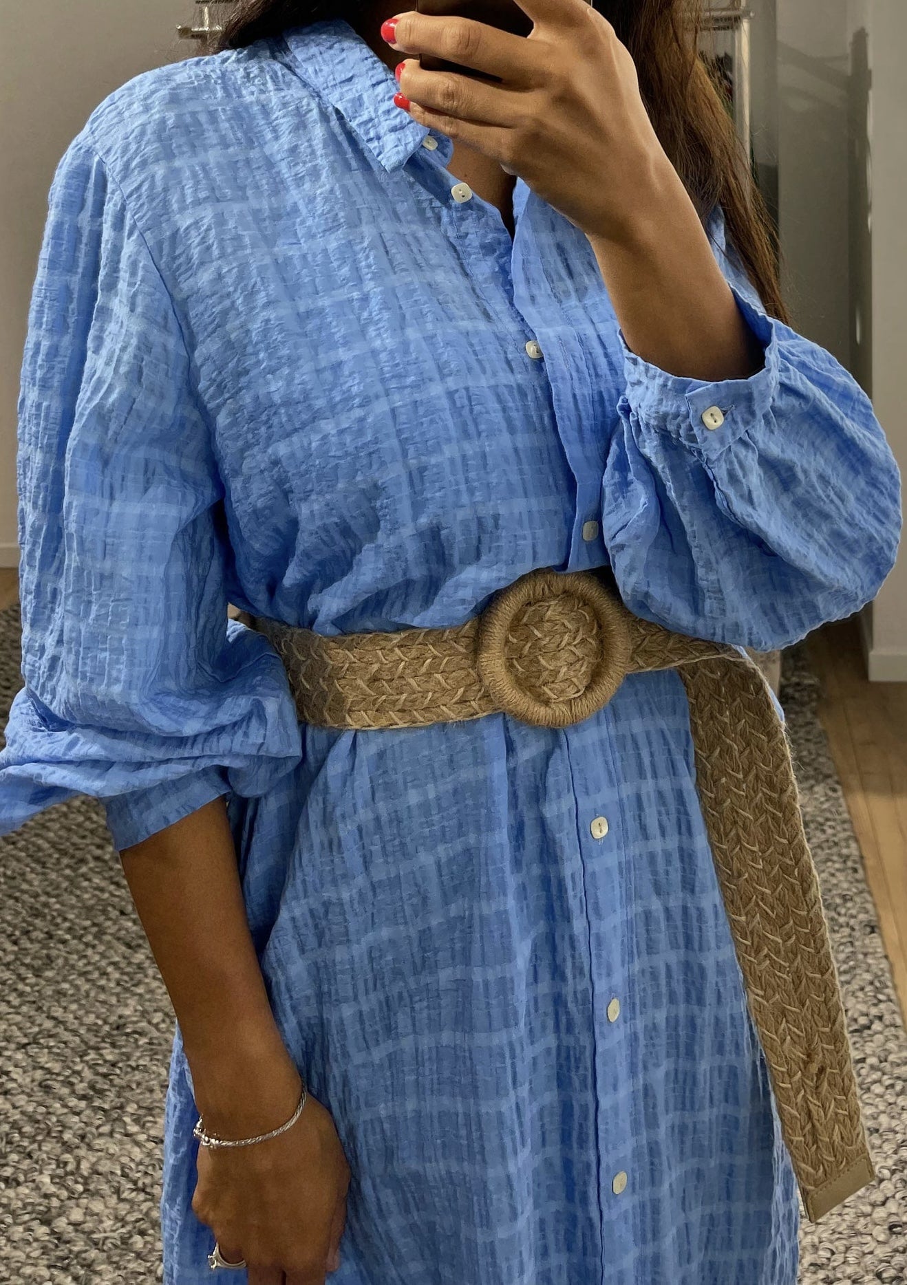 Robe bleue en tissu gaufré avec focus sur la manchette