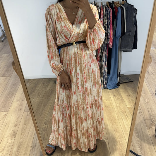 Femme portant une robe longue tie and dye en soie beige avec une ceinture noire, prise en selfie devant un miroir.