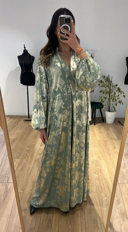 Femme essayant une robe longue imprimée en vert d'eau pour le Ramadan