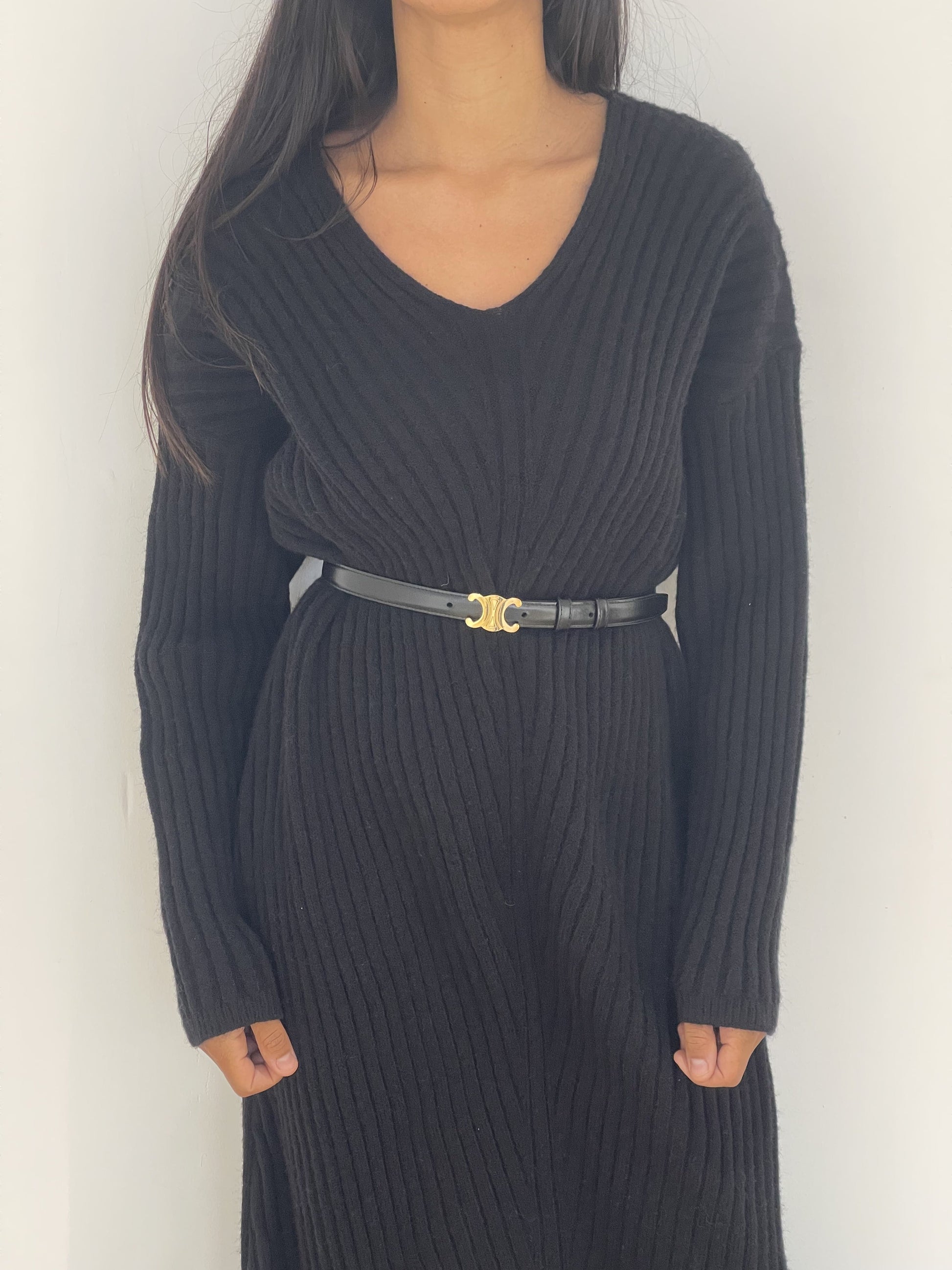 Robe en maille noire avec ceinture dorée pour une touche moderne