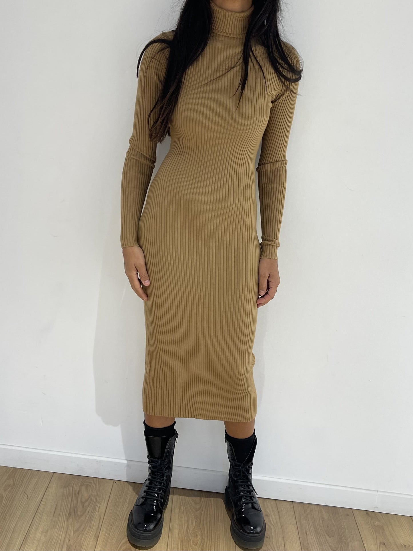 Robe cocktail mi-longue femme de couleur moutarde, côtelée, ajustée, avec bottes noires, idéale pour une allure sophistiquée.