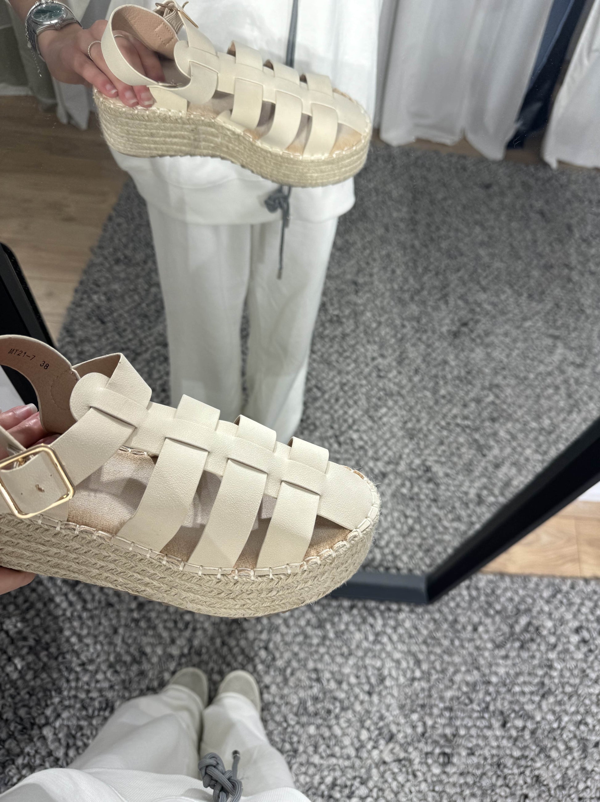 Sandales plates beige pour femme avec détails tressés.