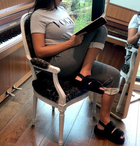 Femme en t-shirt gris lisant sur une chaise élégante
